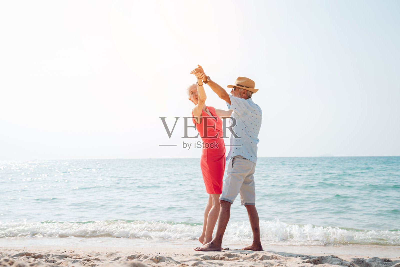 幸福的老年夫妇一起在海滩上散步玩耍照片摄影图片