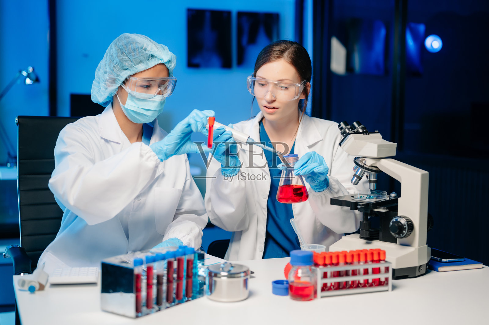 现代医学研究实验室两位科学家工作肖像，使用数码平板，分析样本，谈话。照片摄影图片