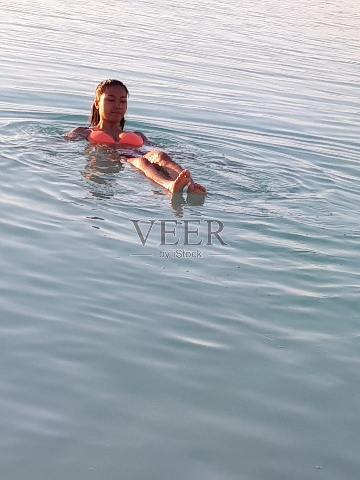 年轻女子在死海游泳放松照片摄影图片