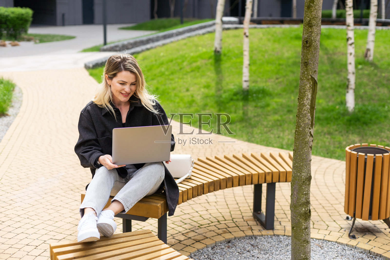 在外面拿着笔记本电脑的年轻女子照片摄影图片