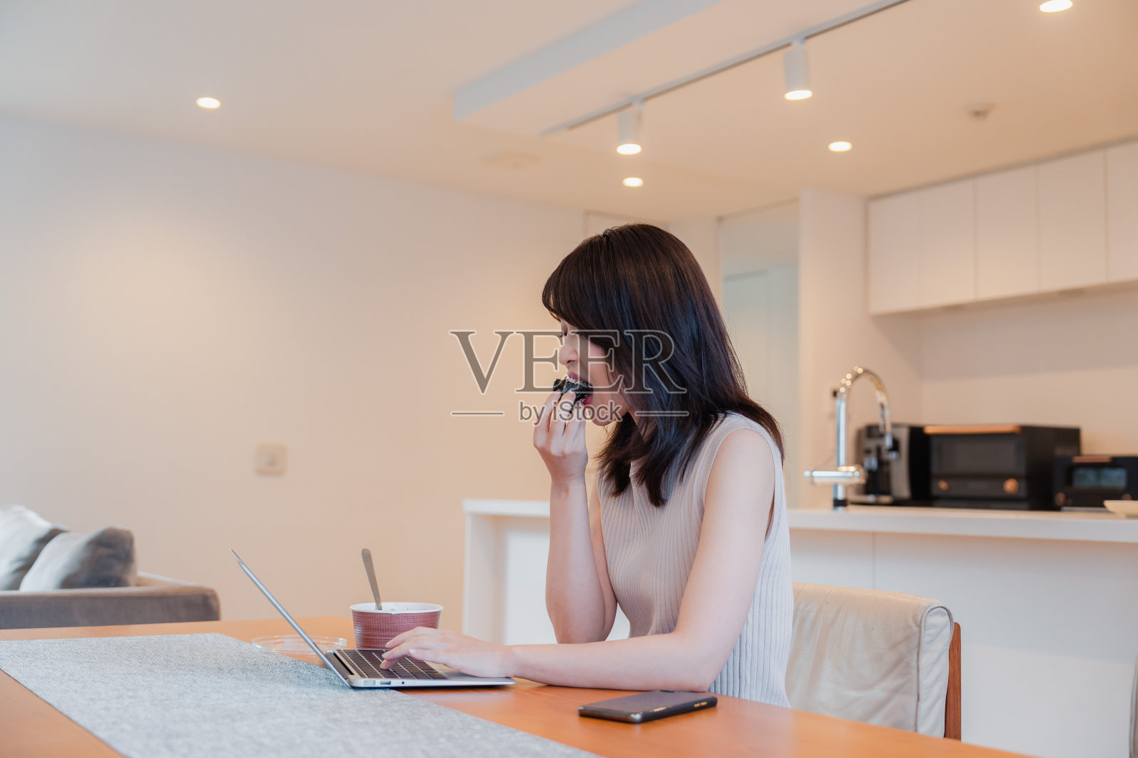 忙女人一边吃晚饭一边远程办公照片摄影图片