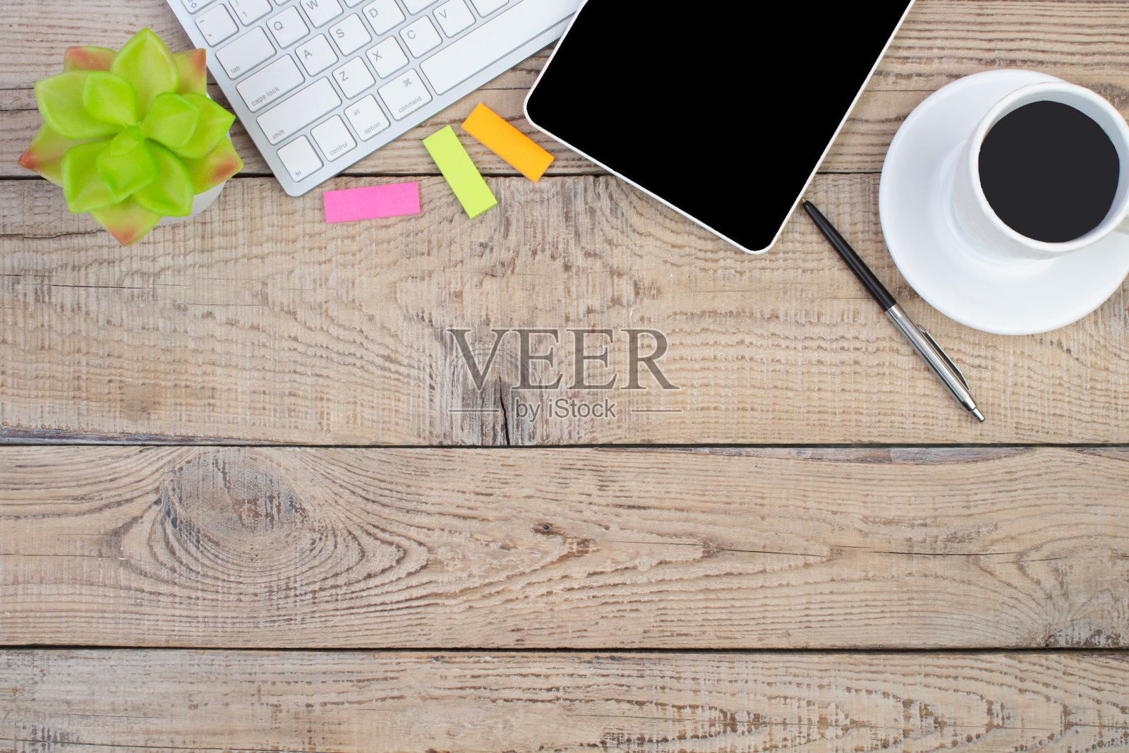 木制的办公桌子上有电脑，钢笔和一杯咖啡，很多东西。带复制空间的俯视图。照片摄影图片