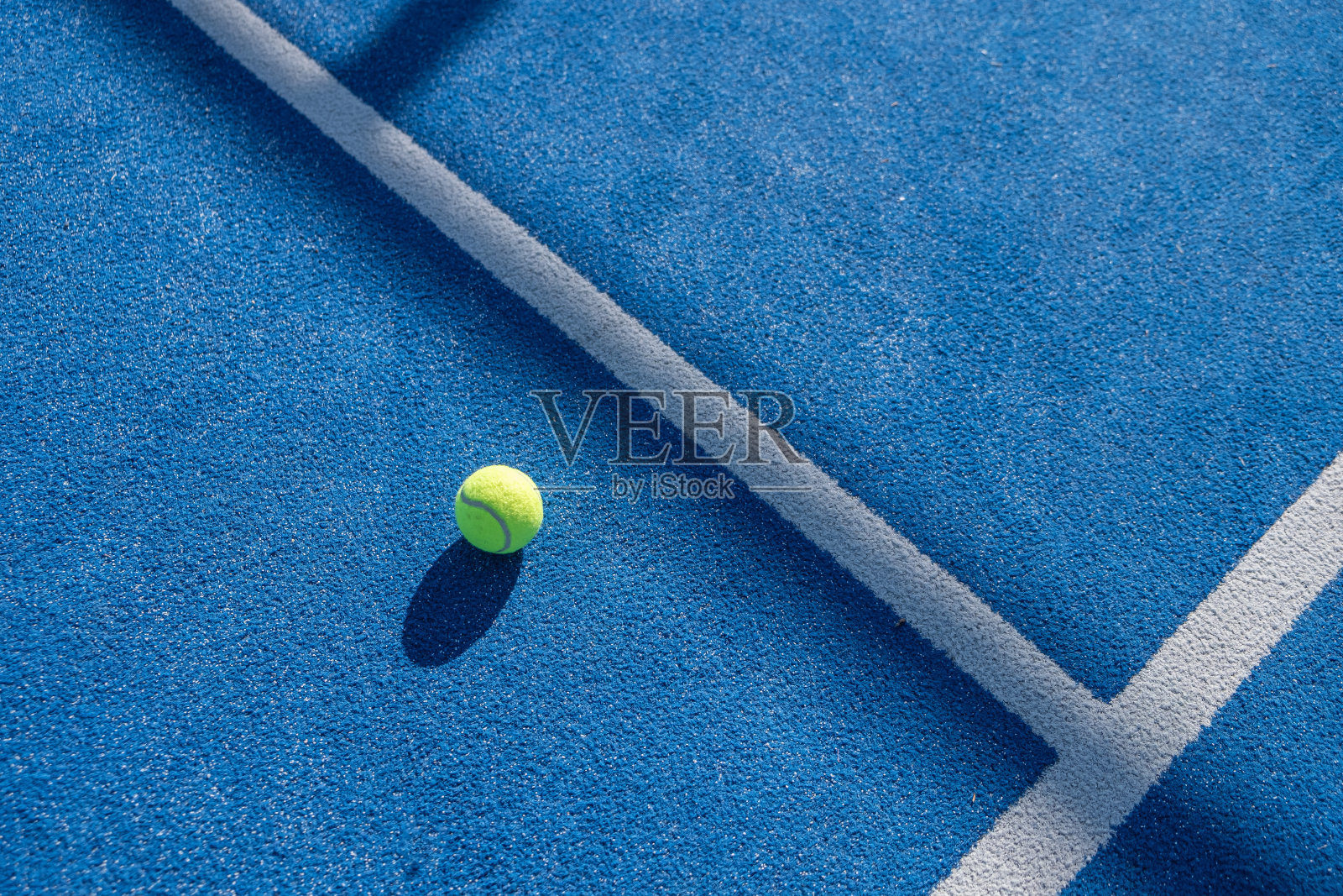 蓝色人造草地球场上的黄色球拍网球照片摄影图片