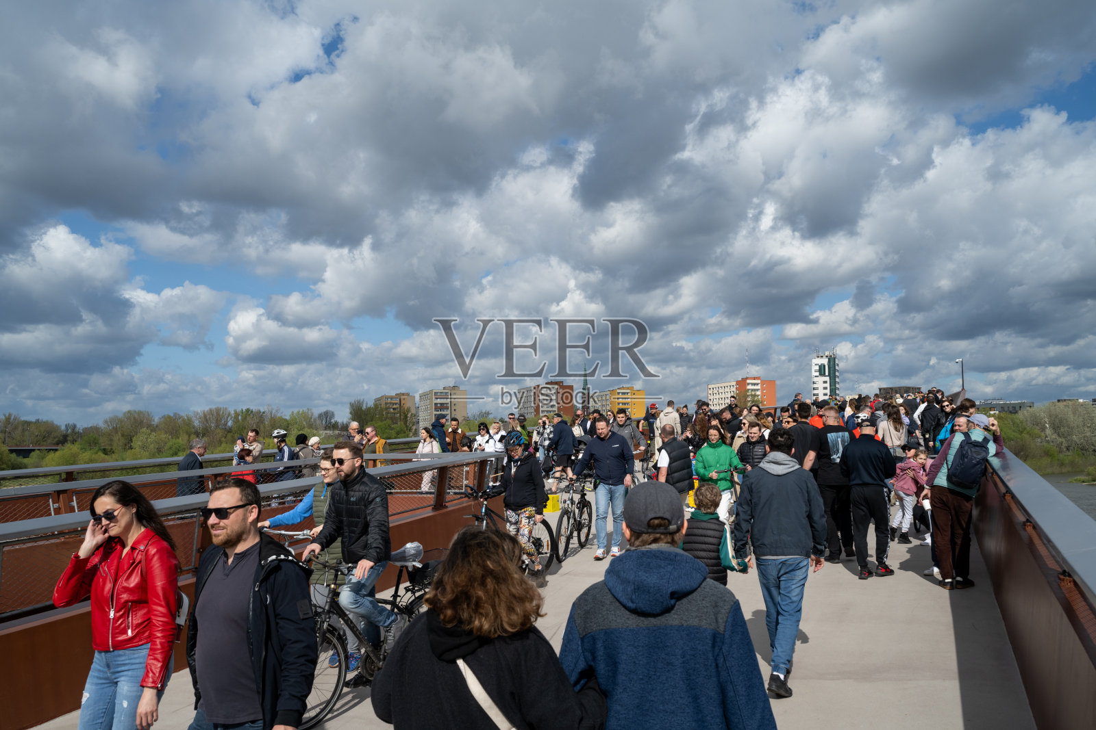 人们聚集在维斯瓦河上的行人和自行车天桥上照片摄影图片