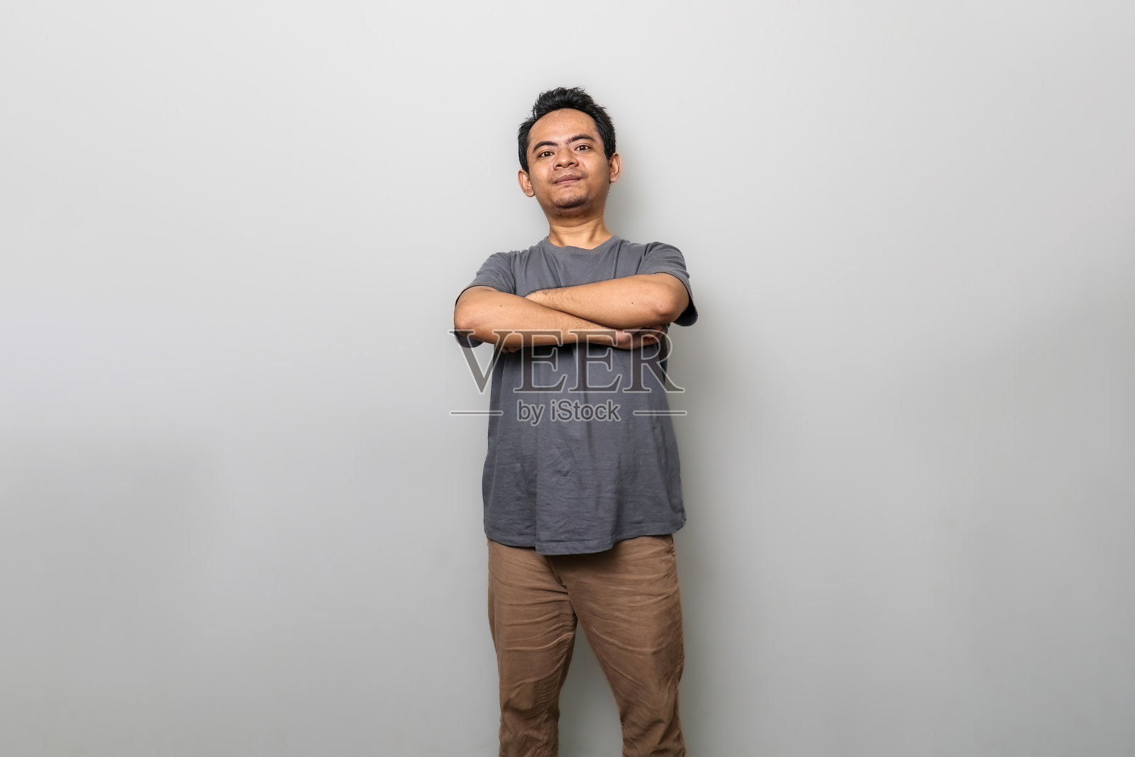 一位英俊的灰色亚洲男子举着红色的哑铃，开心地微笑着照片摄影图片