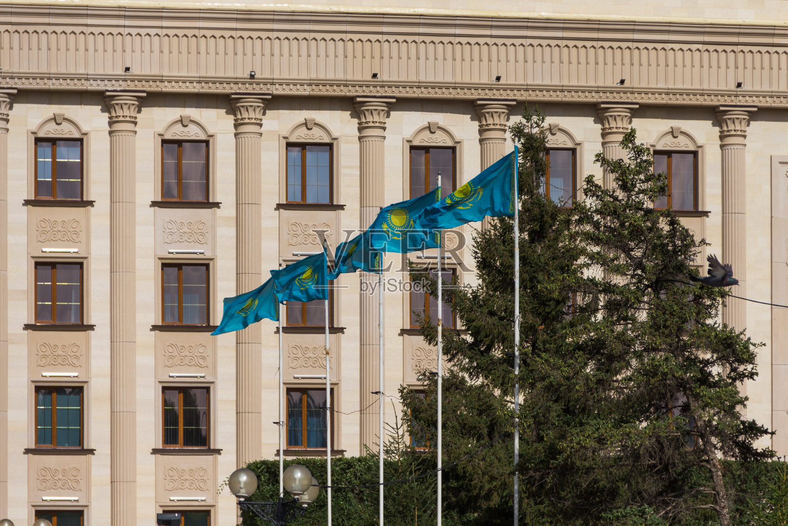 乌拉尔斯克阿基姆办公室大楼背景上的哈萨克国旗照片摄影图片