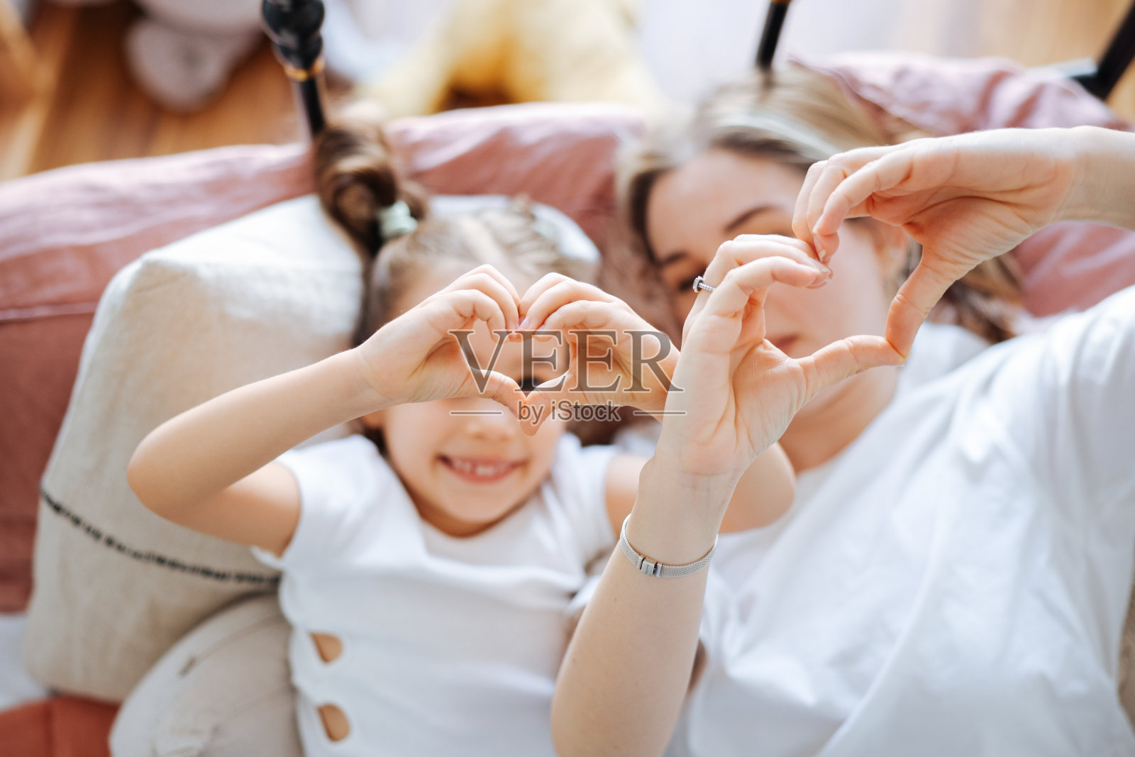 年轻女子和她的女儿早上在床上相遇照片摄影图片