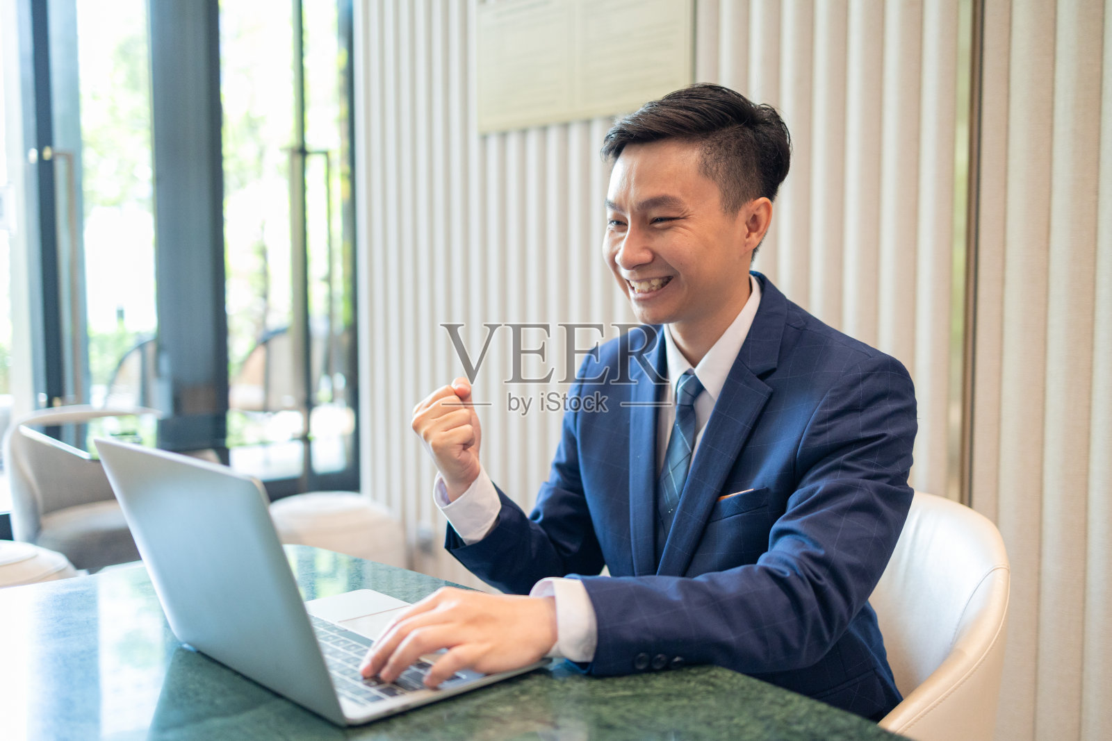 在办公室用笔记本电脑工作的快乐商人照片摄影图片