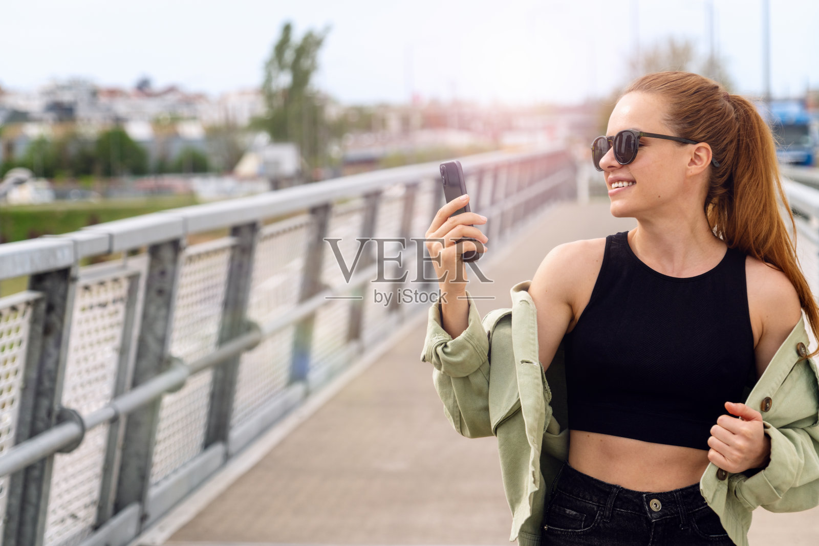 都市女性在城市里散步时用智能手机视频聊天。照片摄影图片