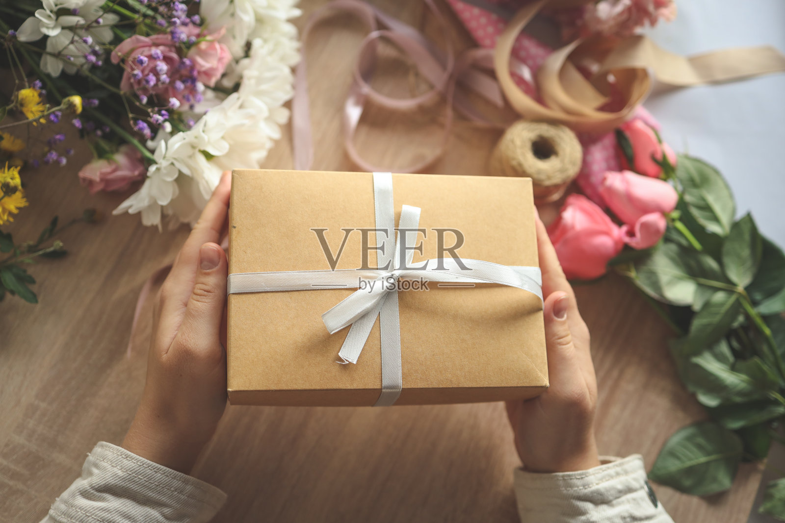 手里拿着礼盒，家里放着鲜花照片摄影图片