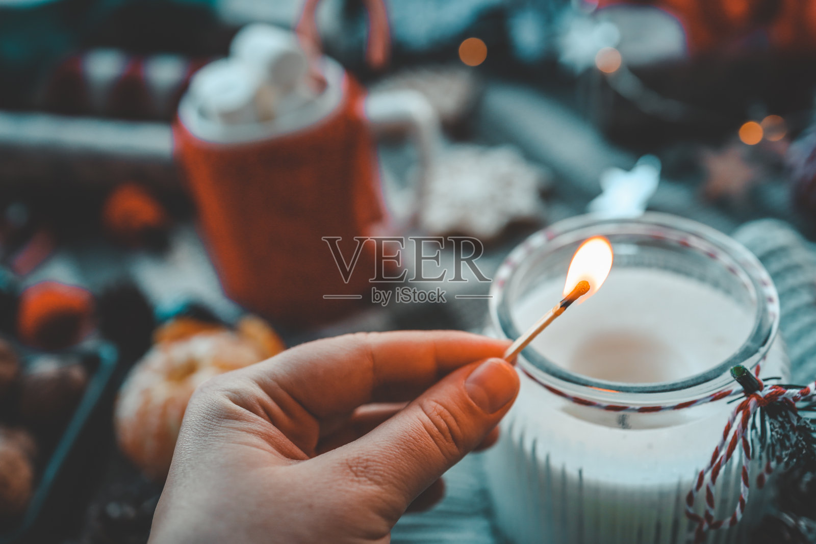 手持火柴点燃蜡烛，圣诞美学照片摄影图片