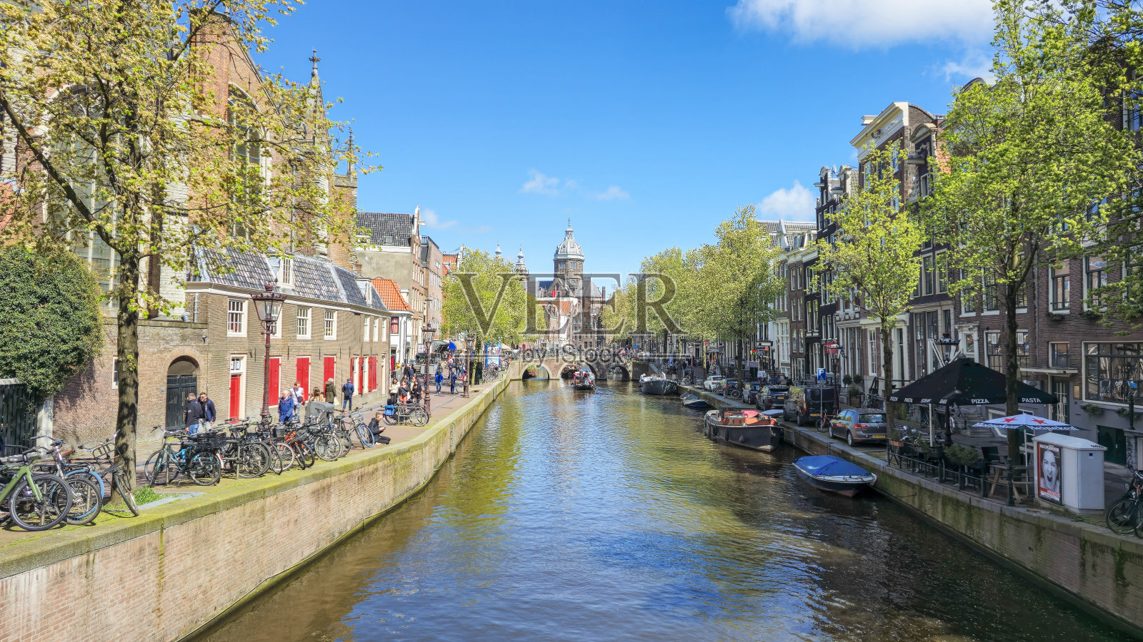 一条河流蜿蜒穿过熙熙攘攘的城市景观，周围是高耸的摩天大楼和熙熙攘攘的街道照片摄影图片