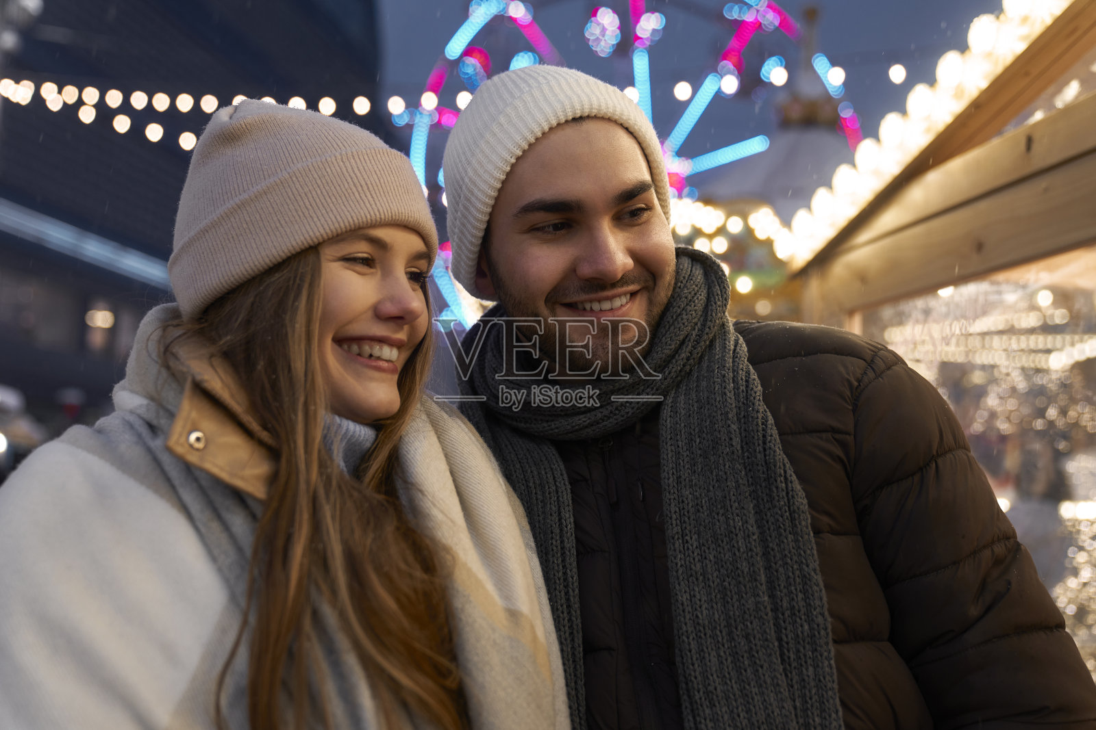 一对白种人夫妇晚上在圣诞市场上玩得很开心照片摄影图片