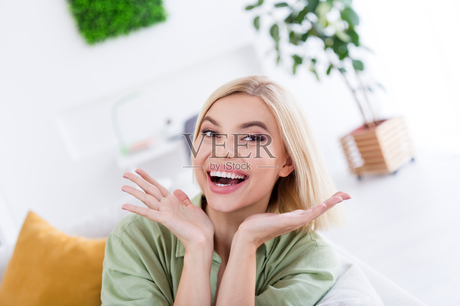 照片中，积极开朗、微笑的可爱女孩展示了明亮的客厅，欣喜地购买了公寓照片摄影图片