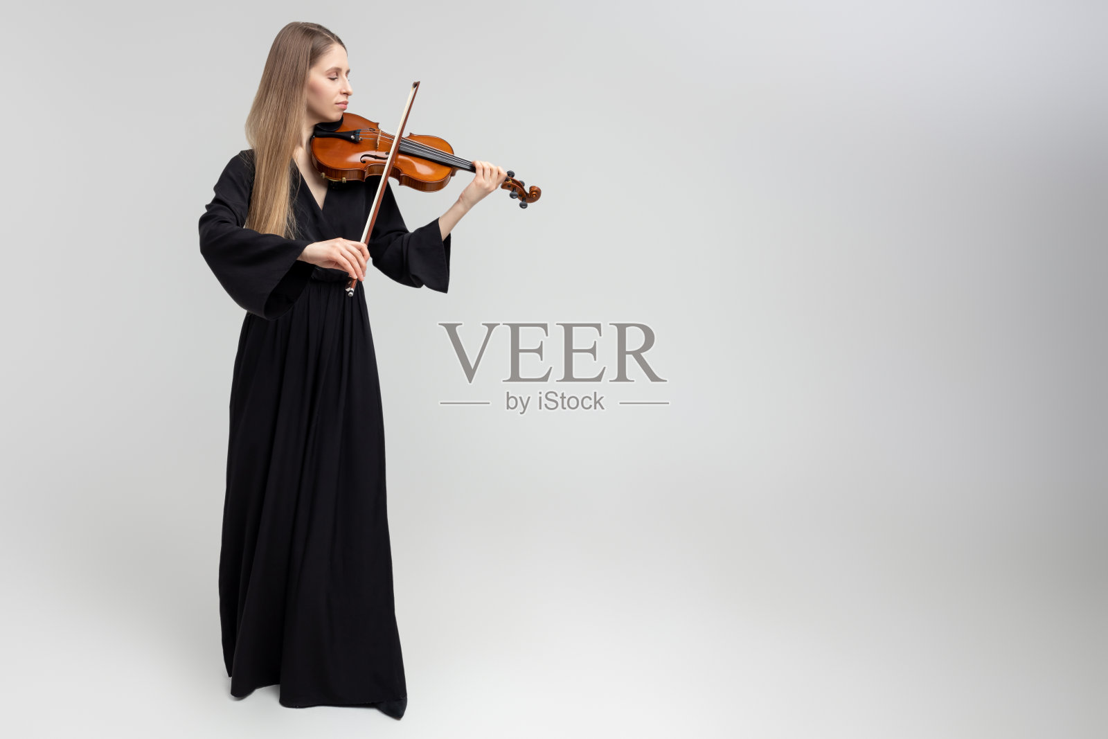迷人的女音乐家拉小提琴的全长肖像照片摄影图片