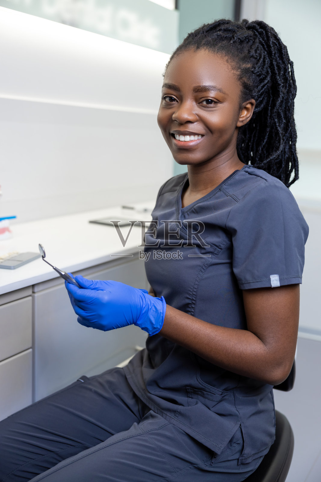 年轻微笑的非裔美国女牙医在她的办公室照片摄影图片