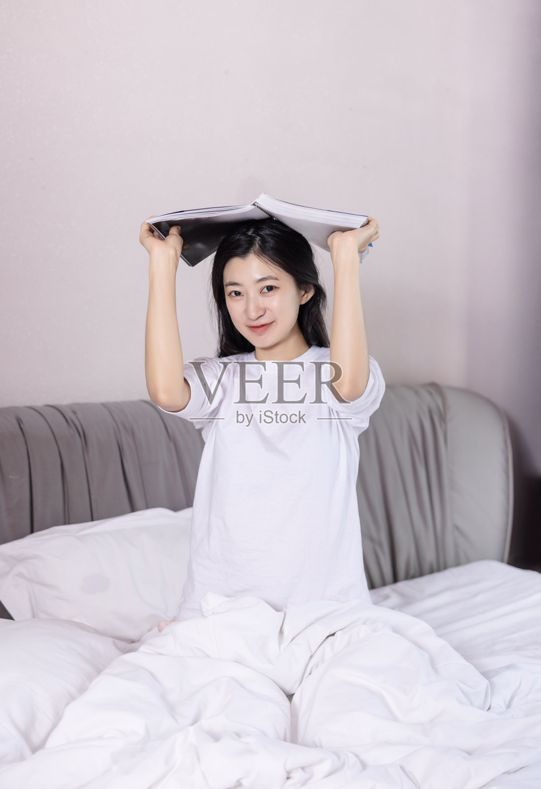 年轻女人坐在床上照片摄影图片