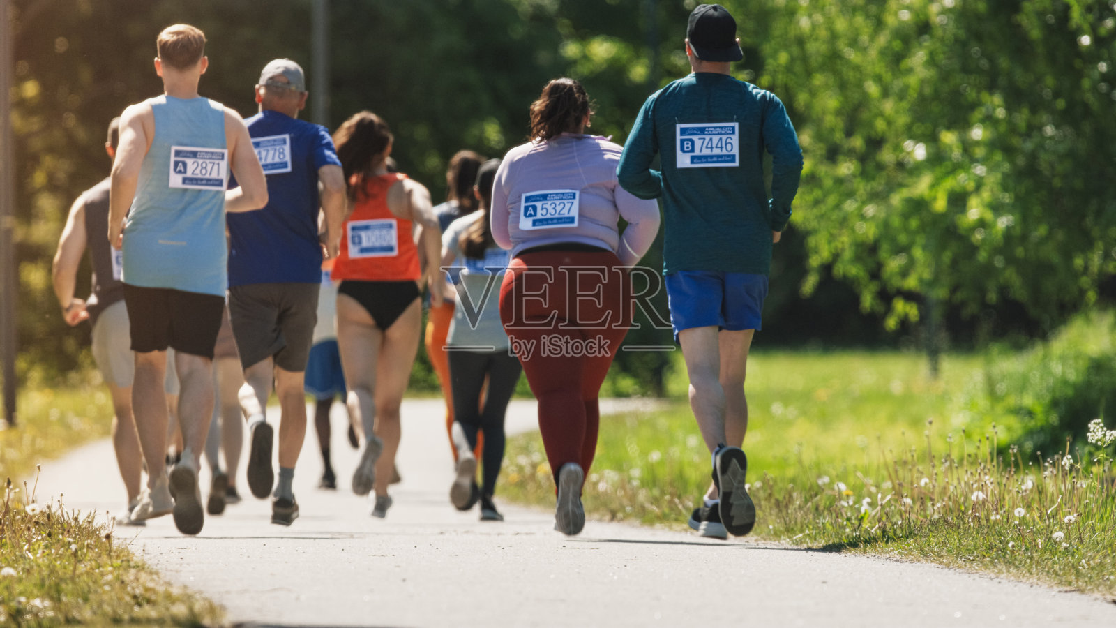 广泛的后视镜不同的马拉松参赛者竞争的比赛终点线:一群人通过公园健康步道和参与马拉松奉献照片摄影图片
