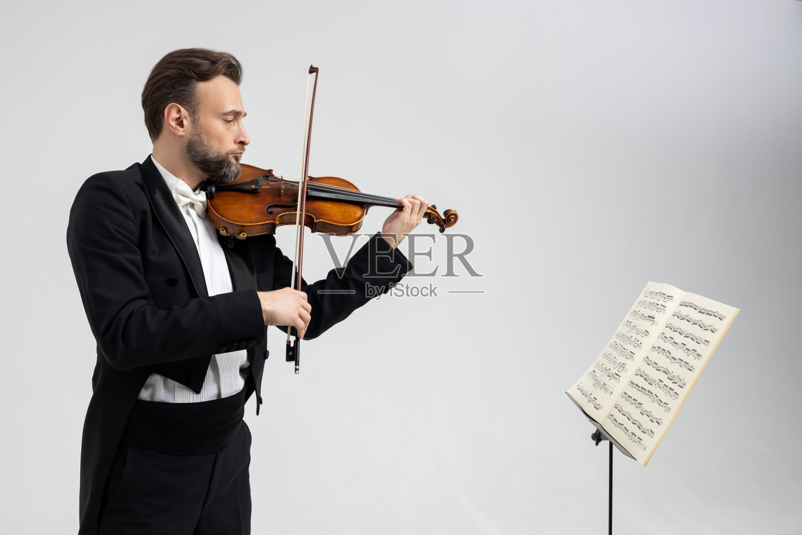 有胡子的小提琴手面对乐谱拉小提琴照片摄影图片