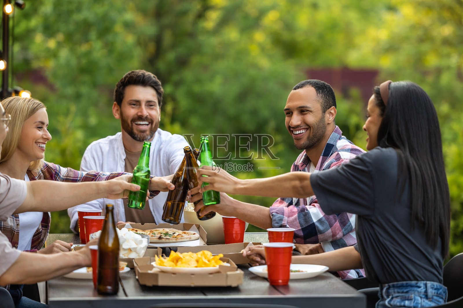 年轻人在户外喝啤酒，享受休闲时光照片摄影图片