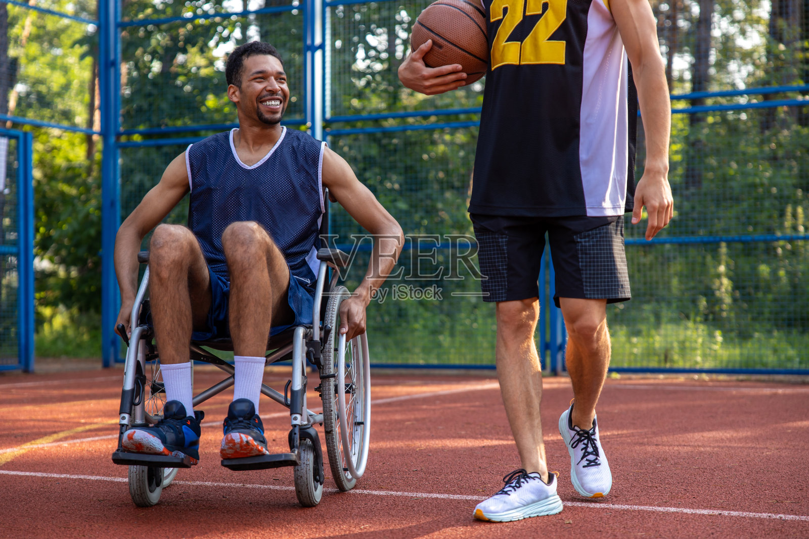 残疾运动员与朋友在球场上进行比赛照片摄影图片