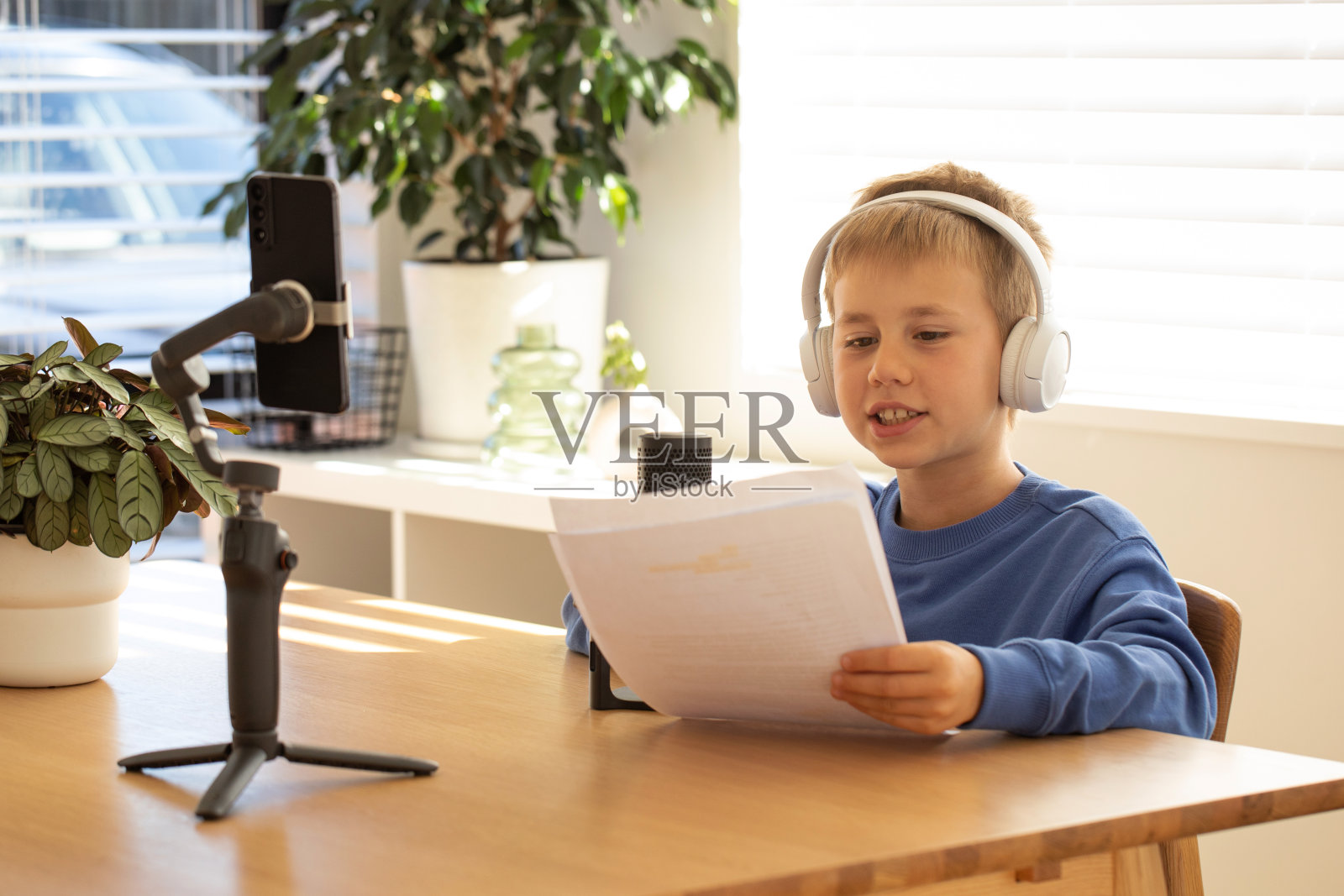 这个男孩正在用耳机和麦克风录制播客。写博客和播客。照片摄影图片