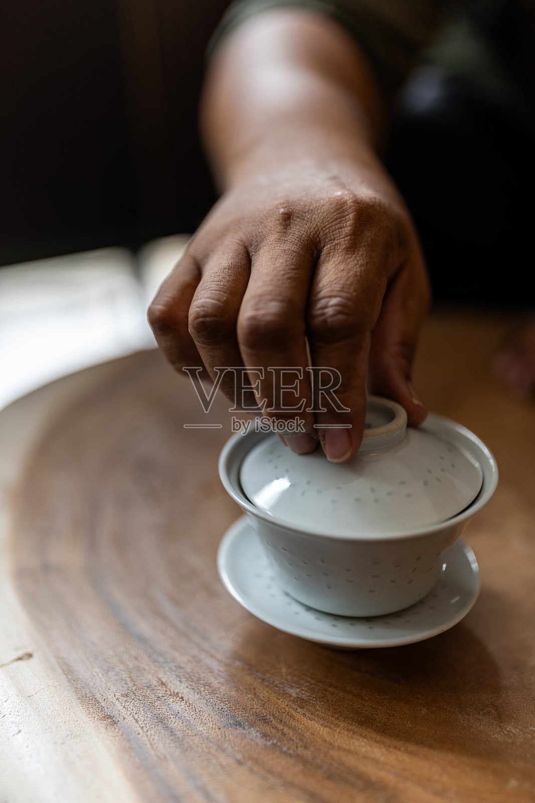 一只手打开了茶杯盖照片摄影图片