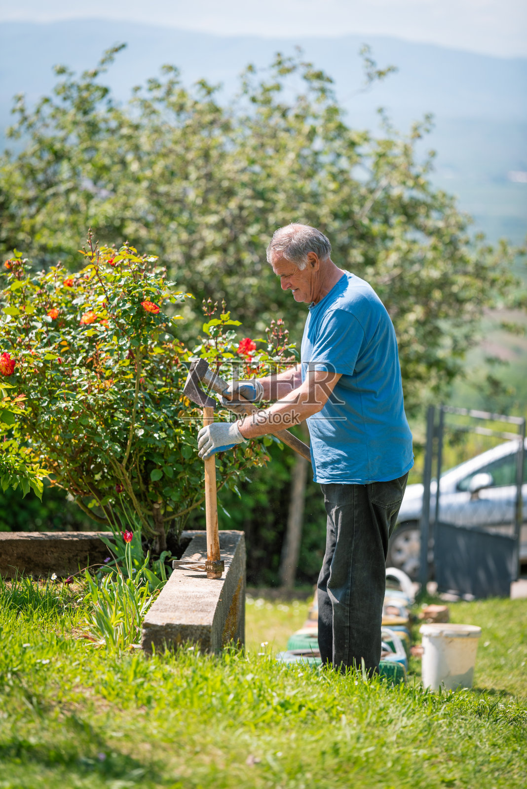 一位老人正在修理他的园艺工具照片摄影图片
