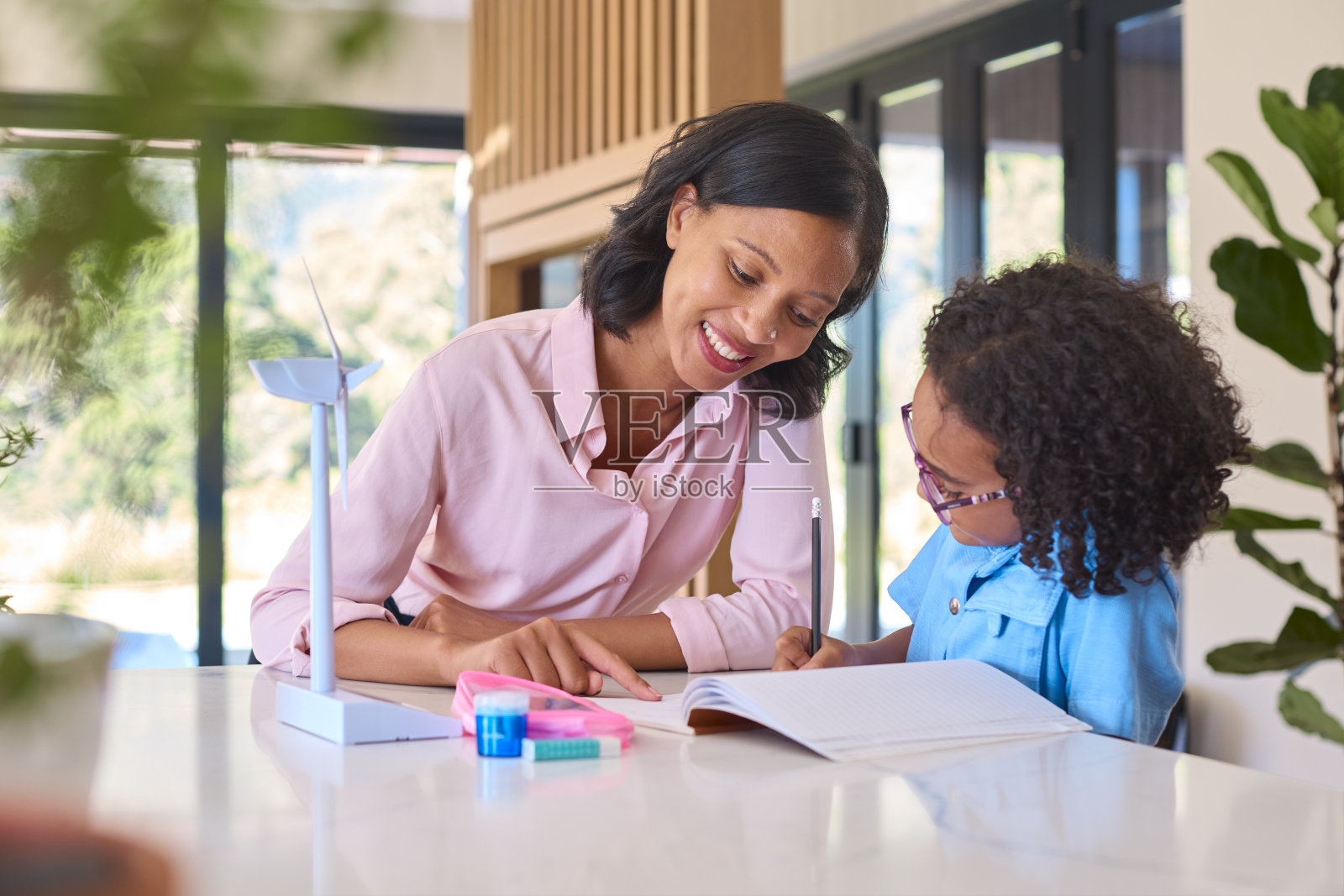 一家母女用模型涡轮机做绿色能源作业照片摄影图片
