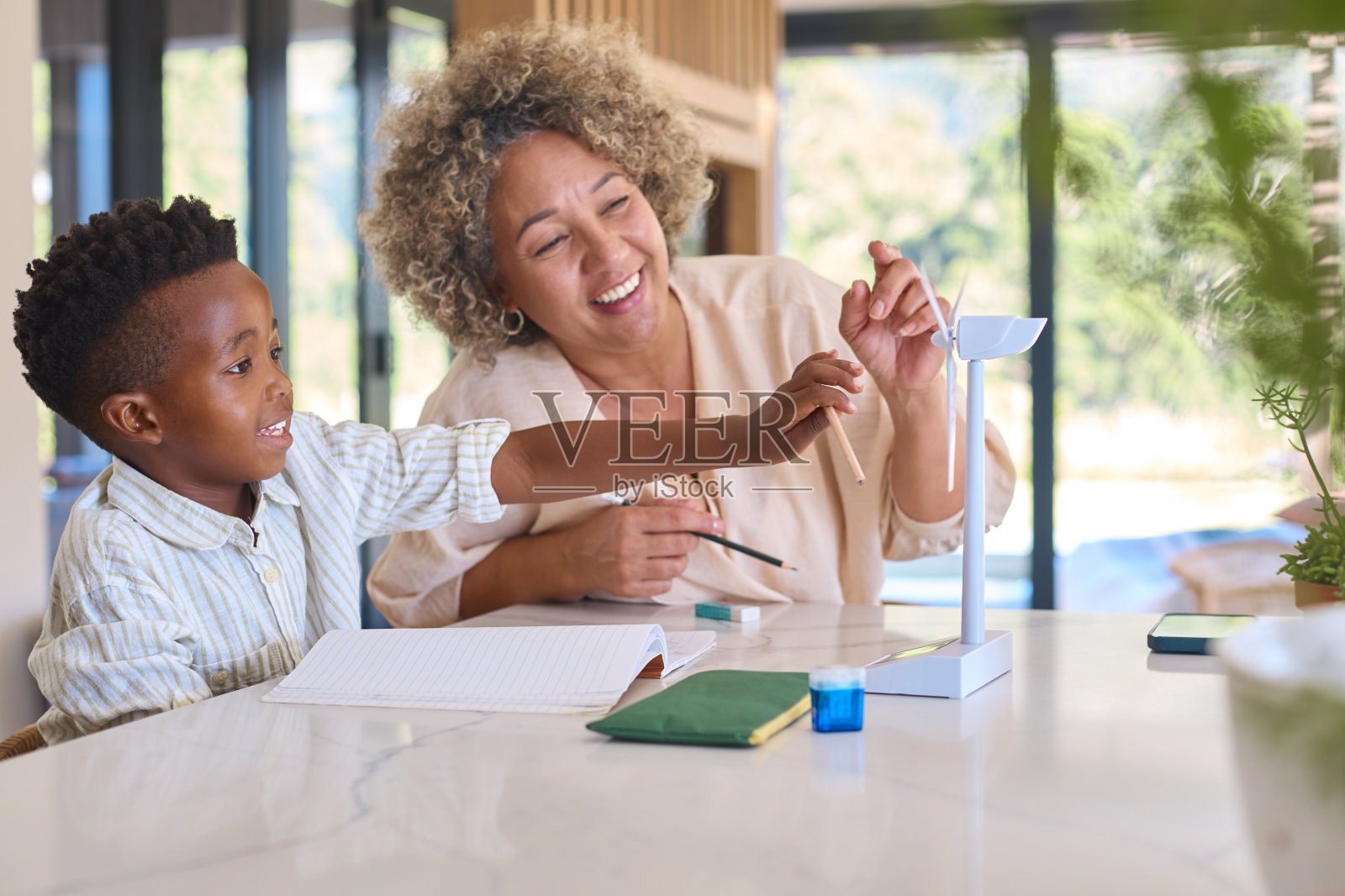 多种族家庭，奶奶和孙子用模型涡轮机做绿色能源的作业照片摄影图片