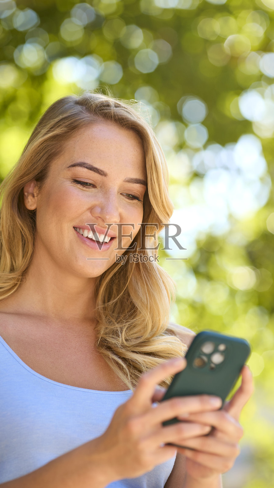 夏日乡村户外的妇女在看手机照片摄影图片