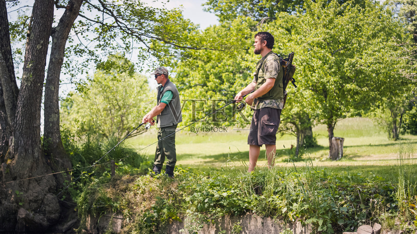 两个渔夫在河边的后景，正在捕鱼照片摄影图片