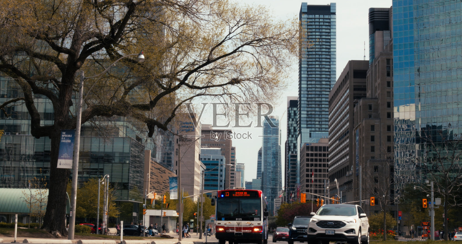 加拿大多伦多- 2023年5月6日:多伦多充满活力的城市生活，在现代摩天大楼的框架下，展示了公共汽车的运动，繁忙的行人和加拿大繁华大都市的城市节奏。照片摄影图片