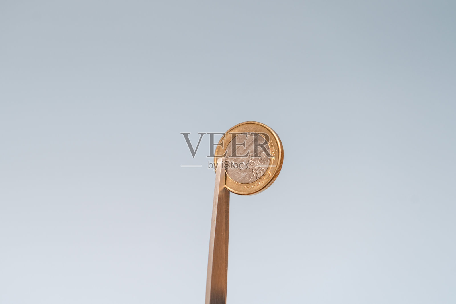 剪刀剪硬币(欧元)在蓝色背景照片摄影图片