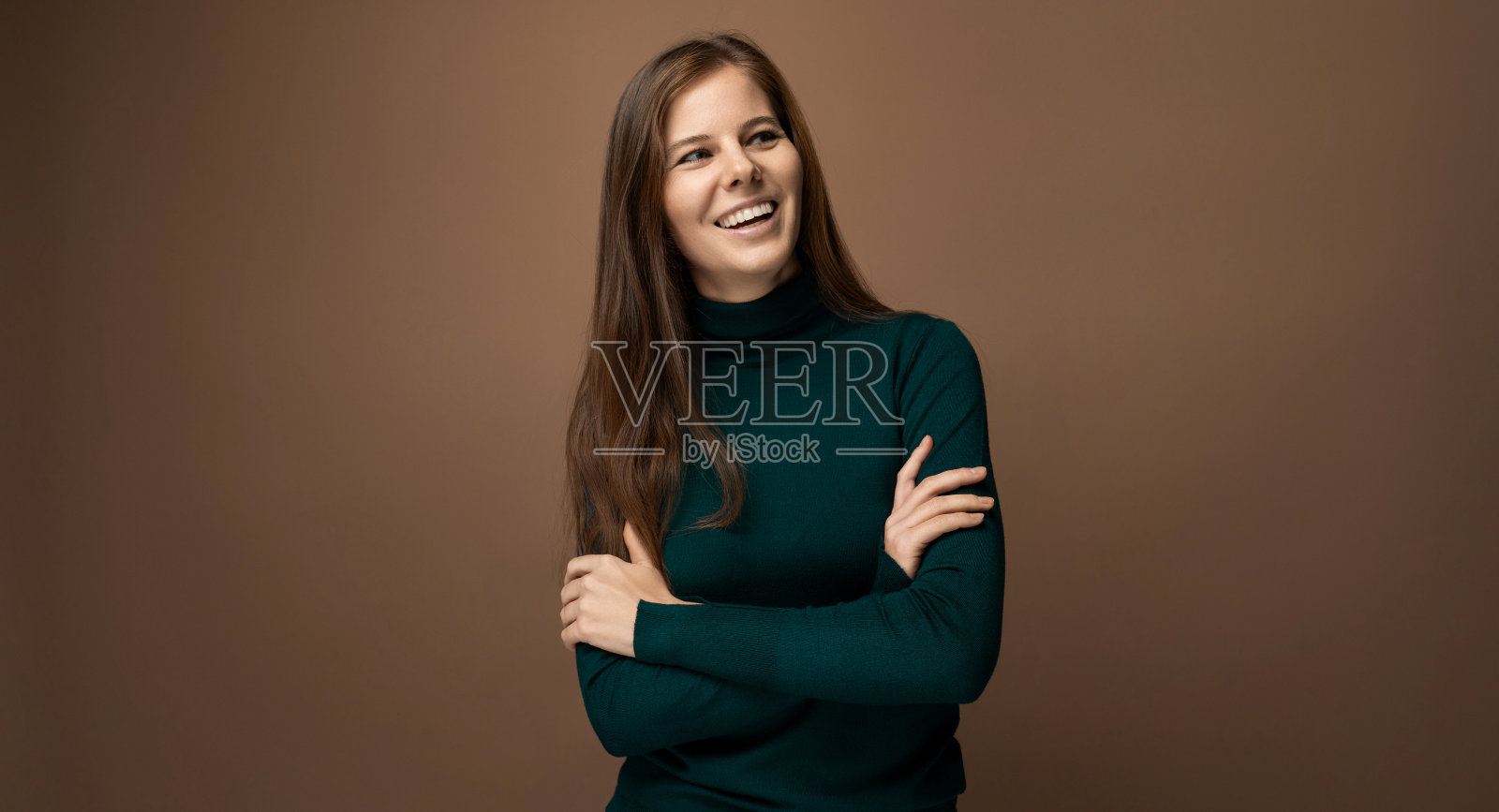 微笑着的30岁女人，棕色眼睛，穿着绿色高领毛衣照片摄影图片