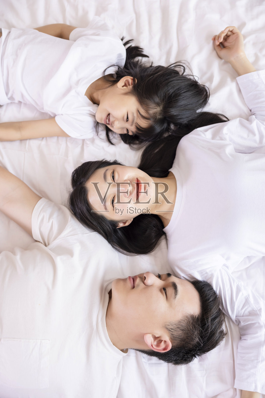 一家三口在床上在卧室里照片摄影图片