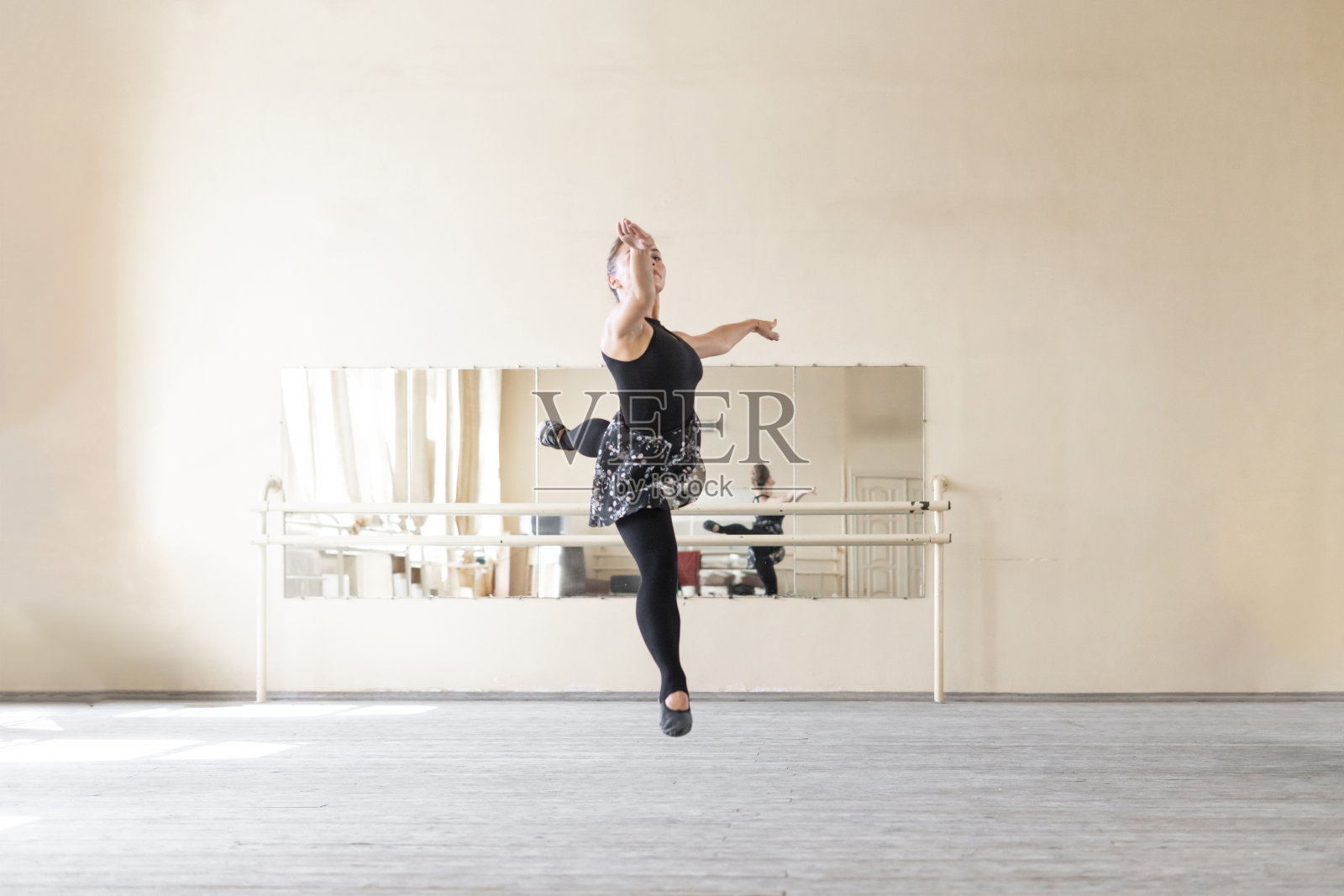女芭蕾舞演员在舞蹈室里翩翩起舞，跳得又高又飞照片摄影图片