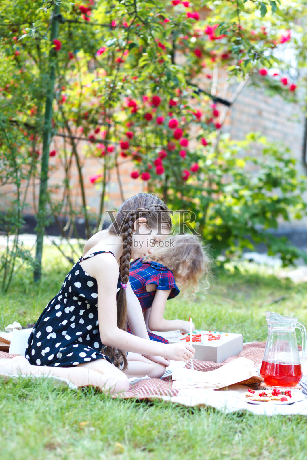 两个女孩正在空地上制作陶瓷马赛克产品。照片摄影图片