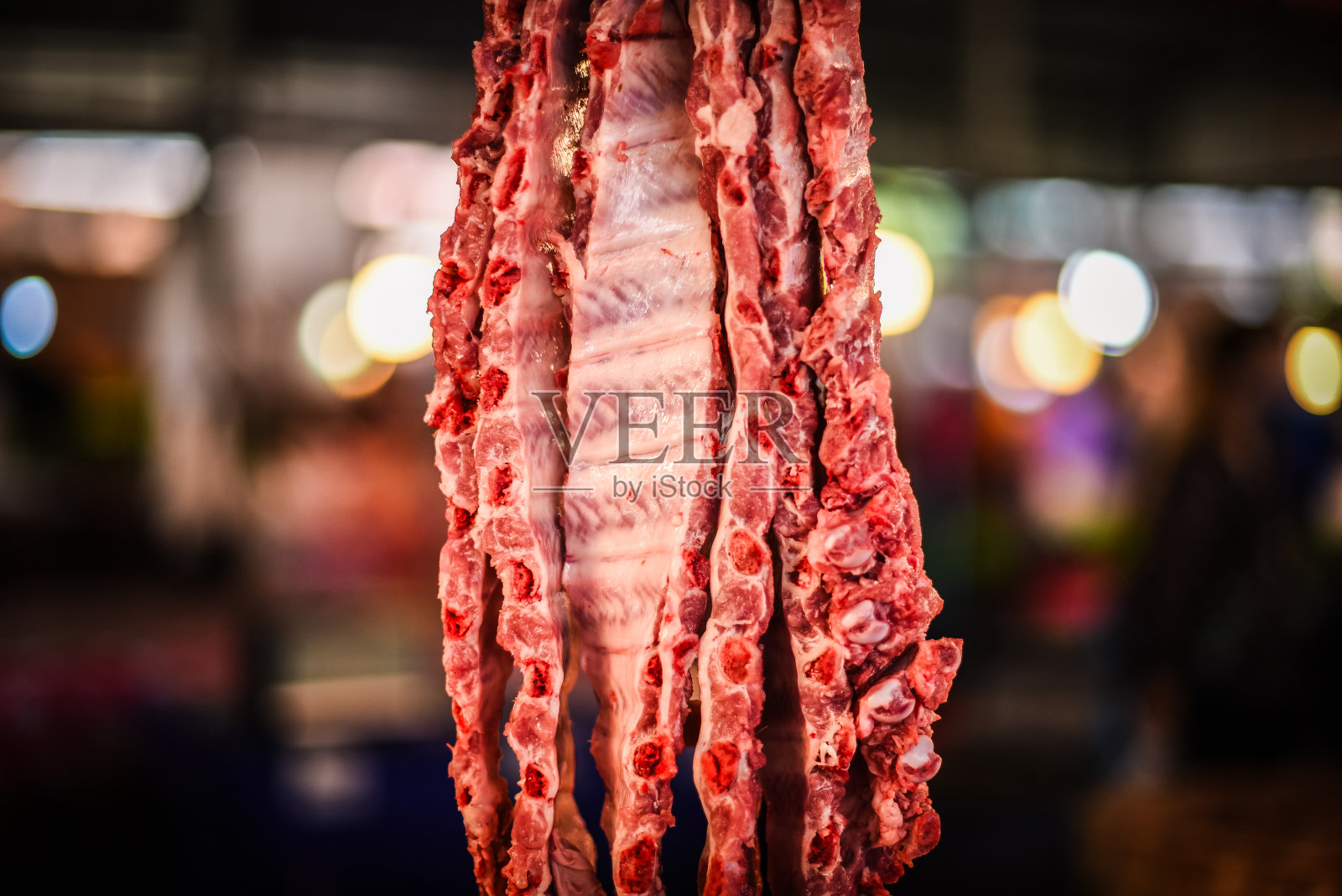 在泰国的一个市场上，猪排骨被切成块出售。照片摄影图片