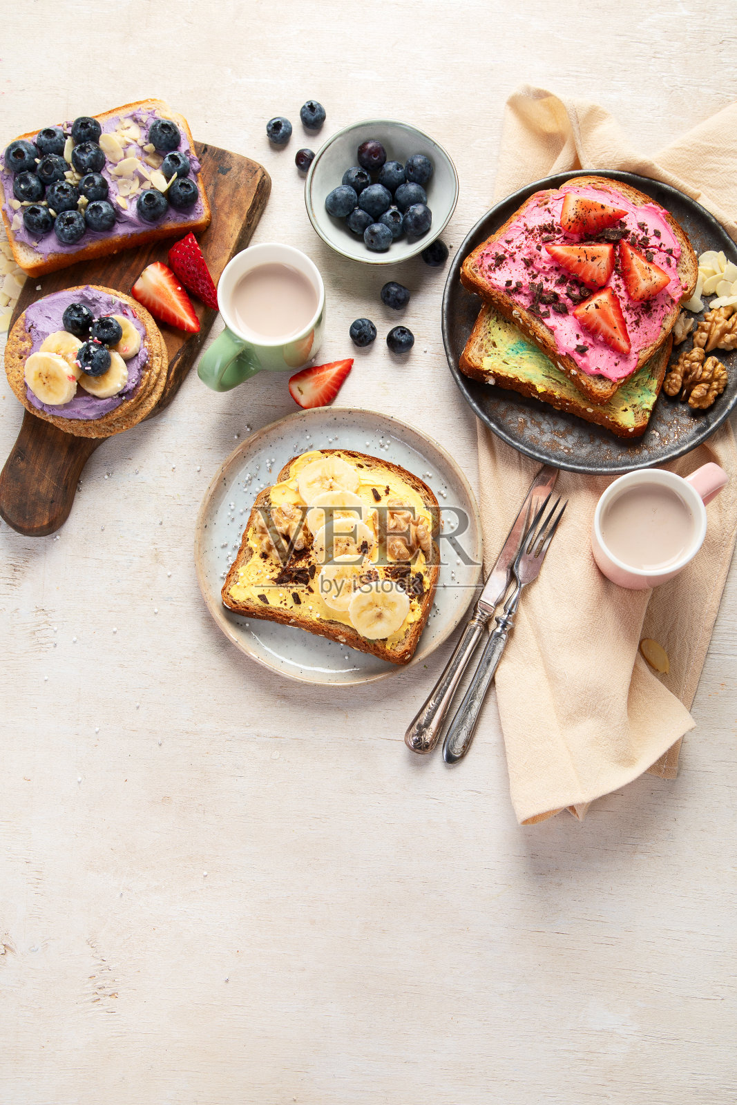 在白色背景上配上烤面包和不同的甜配料。照片摄影图片