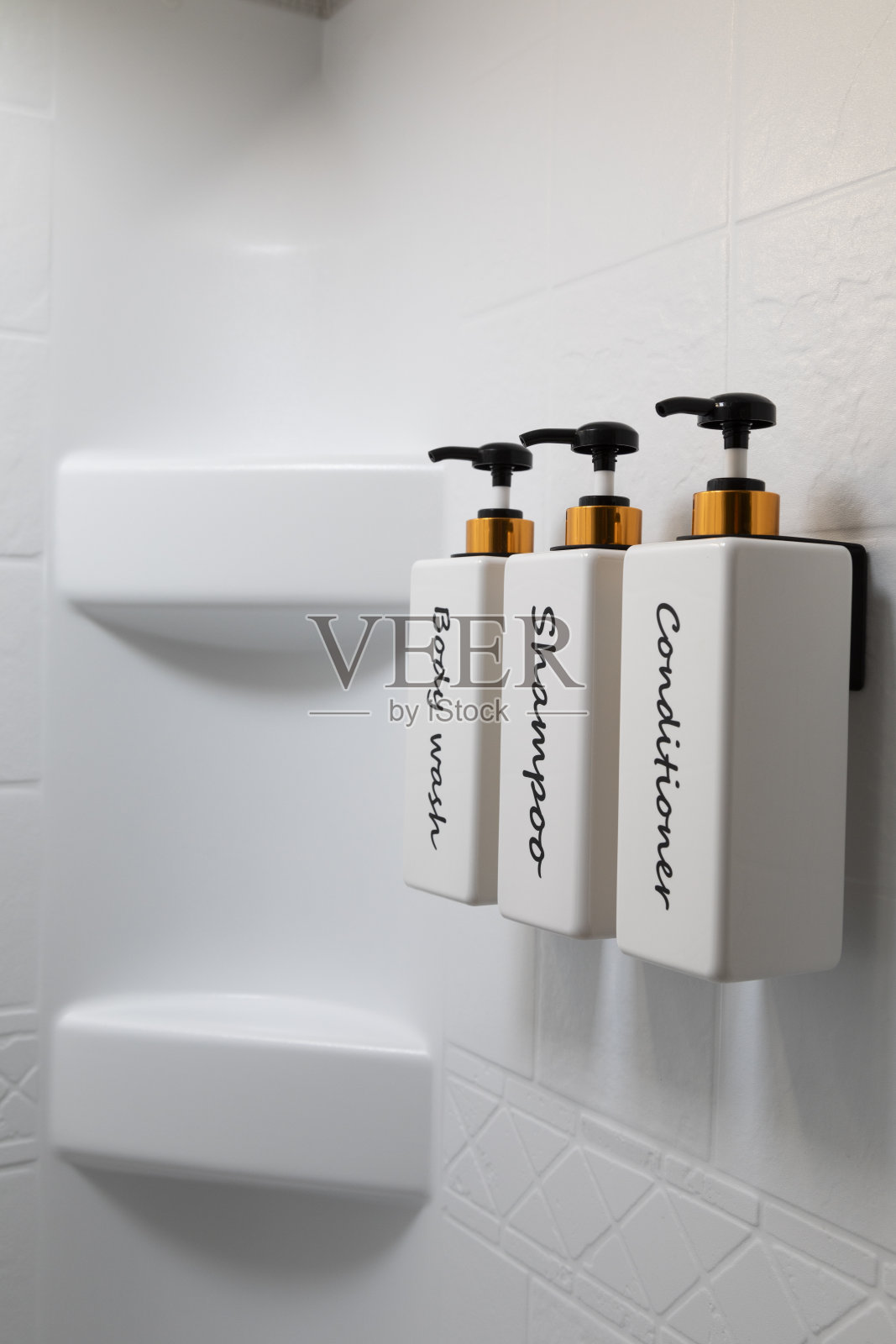 浴室墙上的洗发水和护发素瓶子照片摄影图片