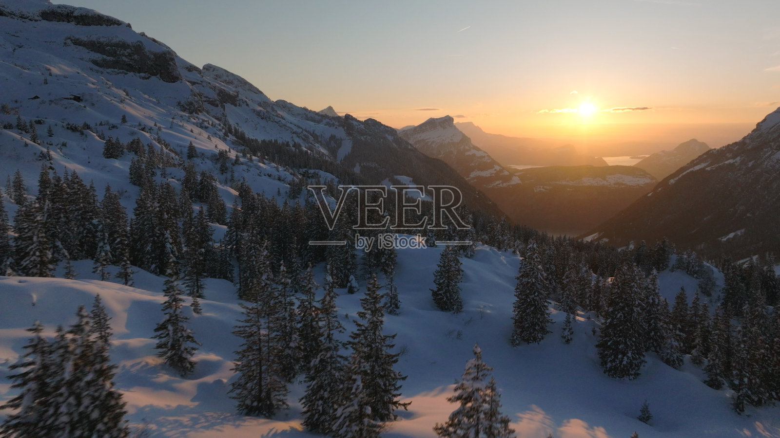 白雪皑皑的山脉和森林上的日出照片摄影图片