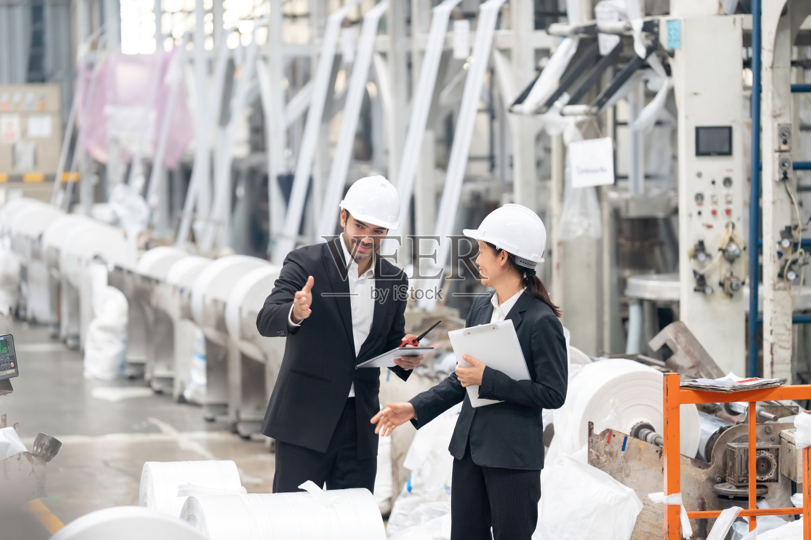 男性和女性工程师合作开发用于工业环境的机器人系统，利用他们不同的专业知识来克服技术挑战。照片摄影图片