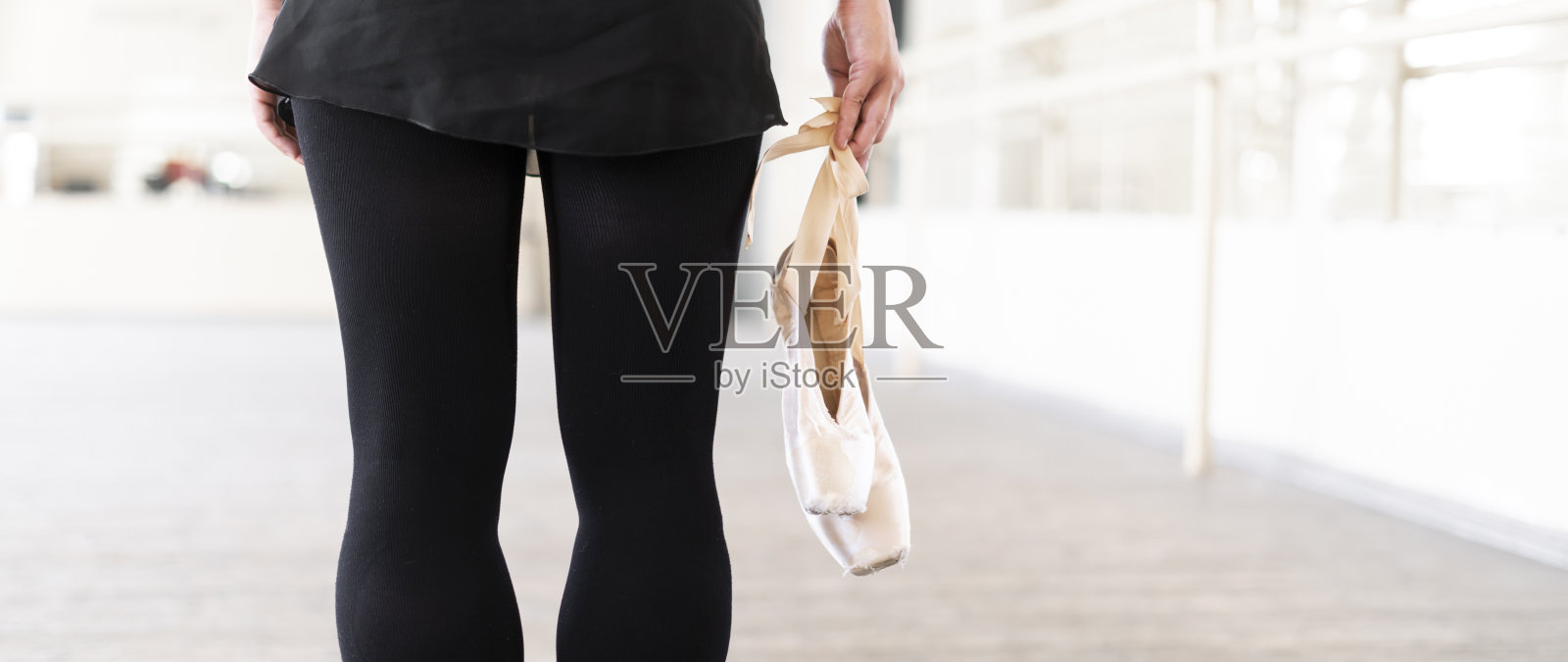 芭蕾舞演员在舞蹈室里拿着足尖鞋照片摄影图片