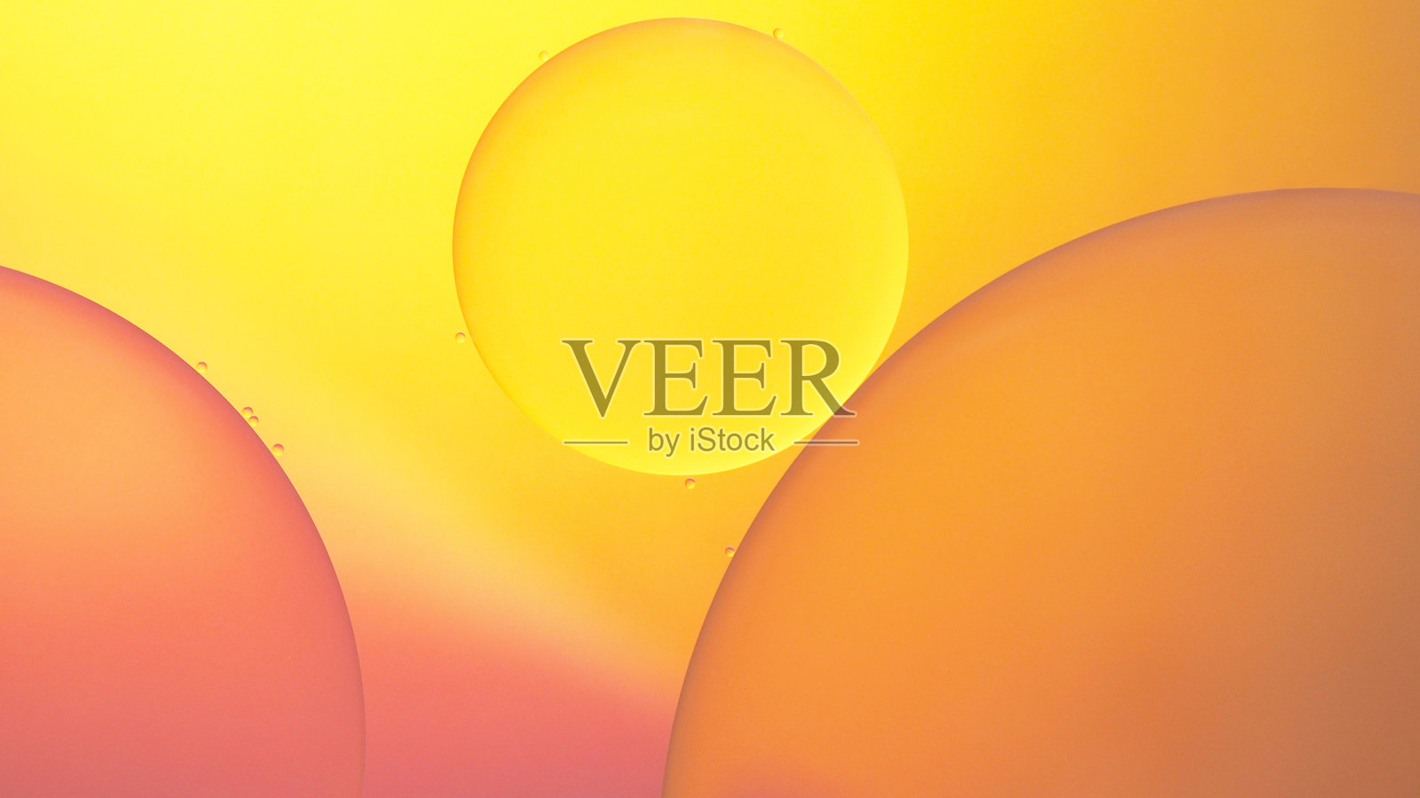 在黄色到橙色的渐变抽象背景上的油和水的微距摄影照片摄影图片