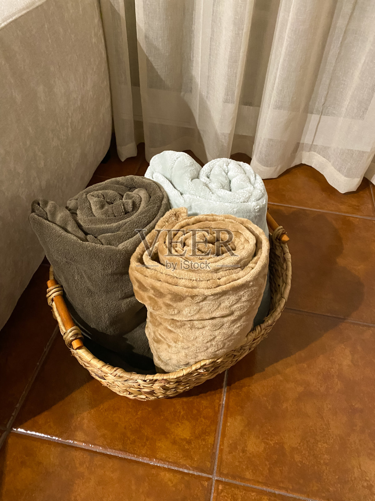 在房子里的客厅里，沙发旁边的篮子里放着毯子照片摄影图片