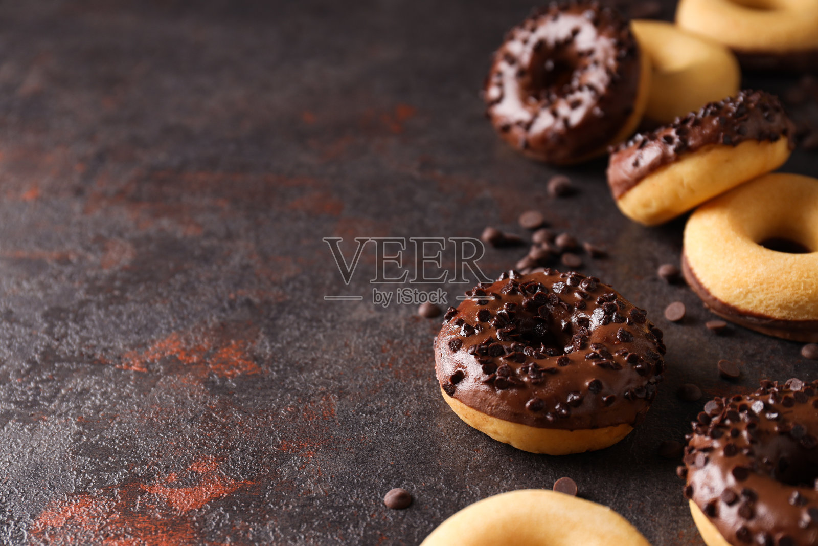 巧克力甜甜圈和巧克力片在深灰色的背景，文字的空间照片摄影图片