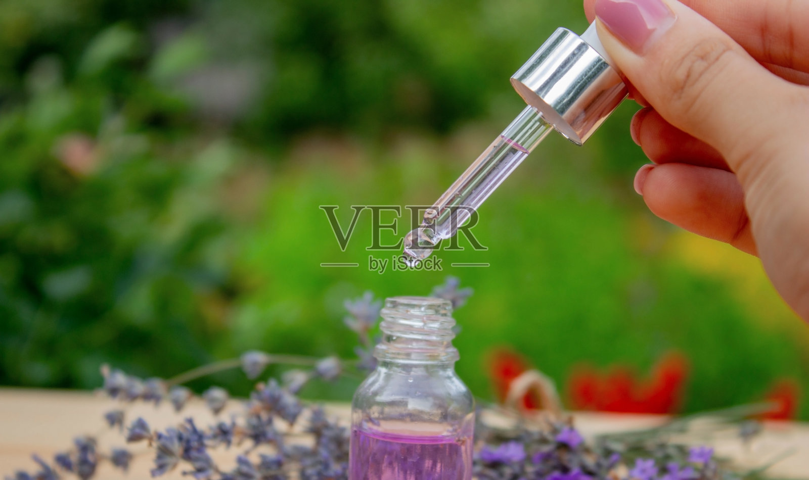 木制背景上的薰衣草精油玻璃瓶。照片摄影图片