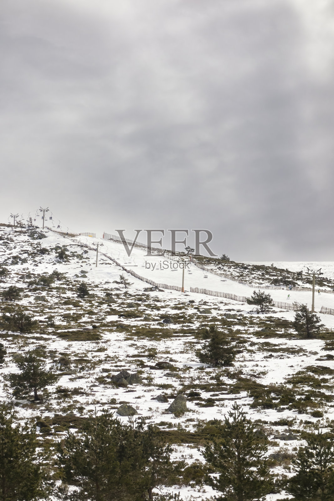 滑雪场周围有植被和树木，缆车过去常被用来到山顶照片摄影图片