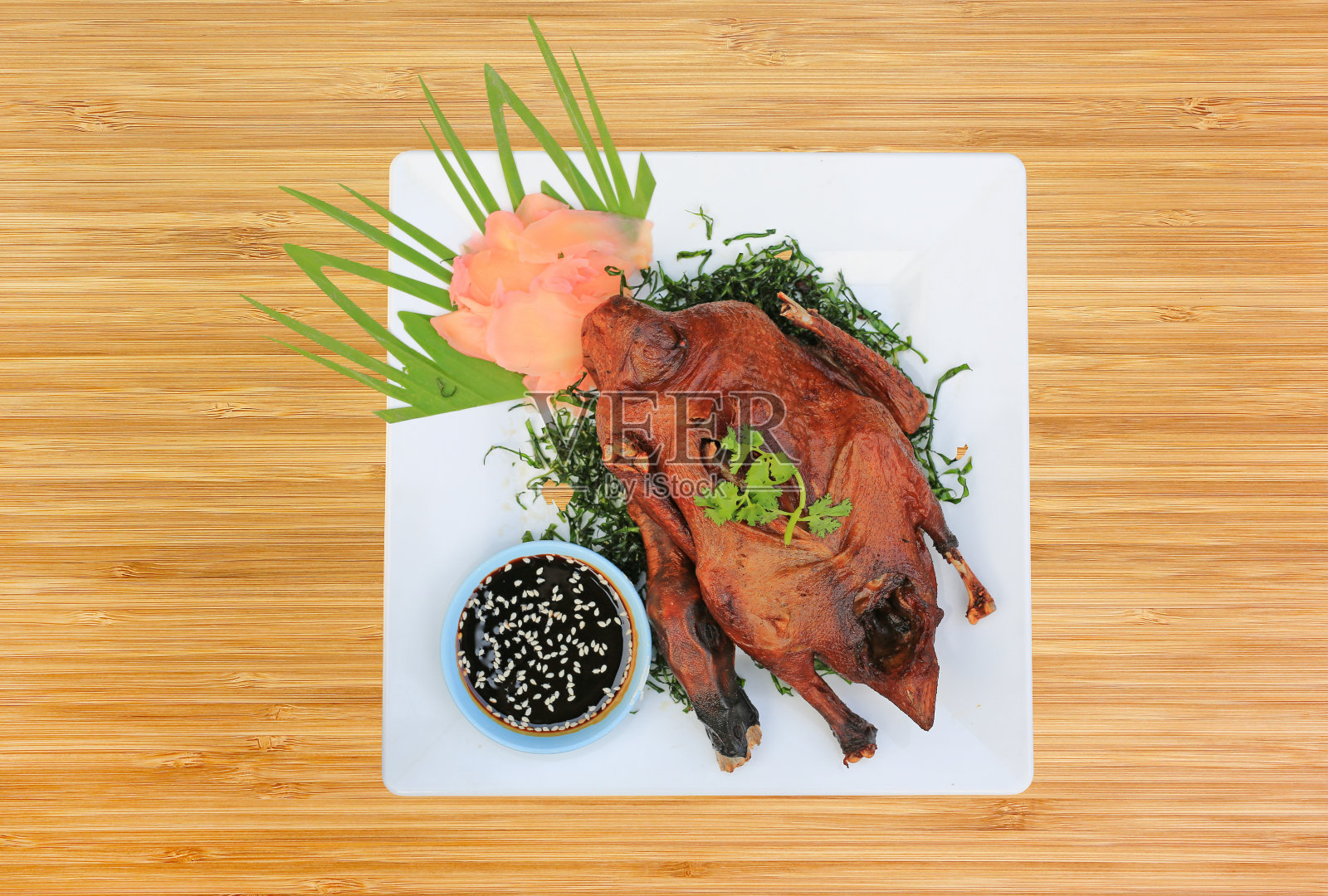 竹木背景上的烤鸭。脆皮全鸭，北京烤鸭。从上面看。照片摄影图片